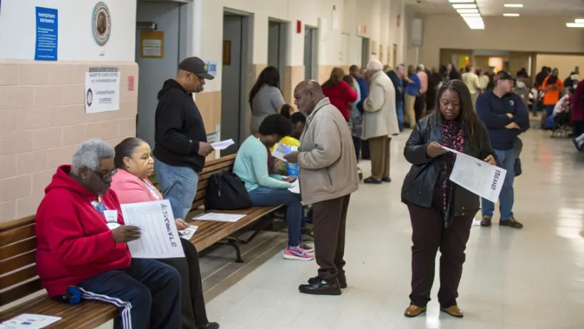 Diverse group of people waiting in line at a polling station to cast their votes